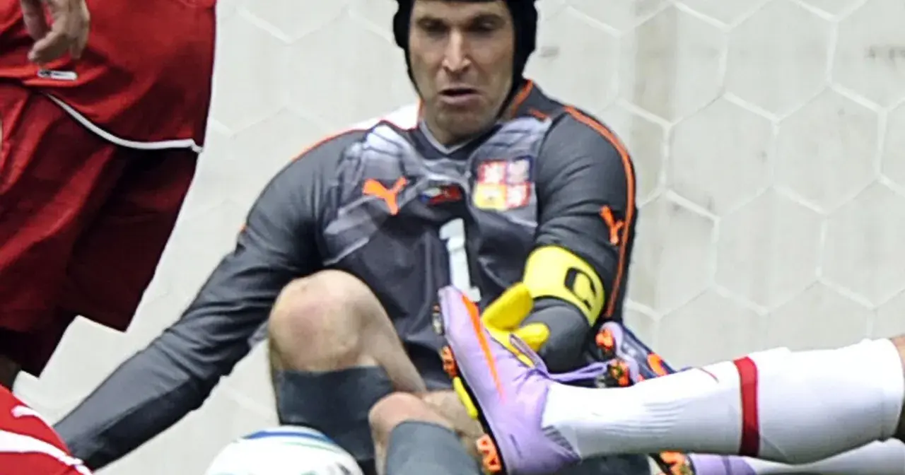 Petr Čech w kasku po groźnej kontuzji głowy, w akcji ratuje bramkę.