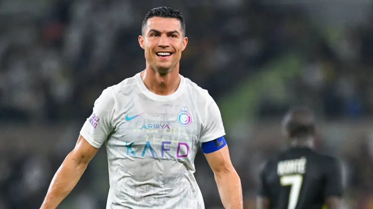 Uśmiechnięty Cristiano Ronaldo w białej koszulce Al Nassr. Ile goli strzelił Ronaldo? To pytanie nurtuje fanów na całym świecie.