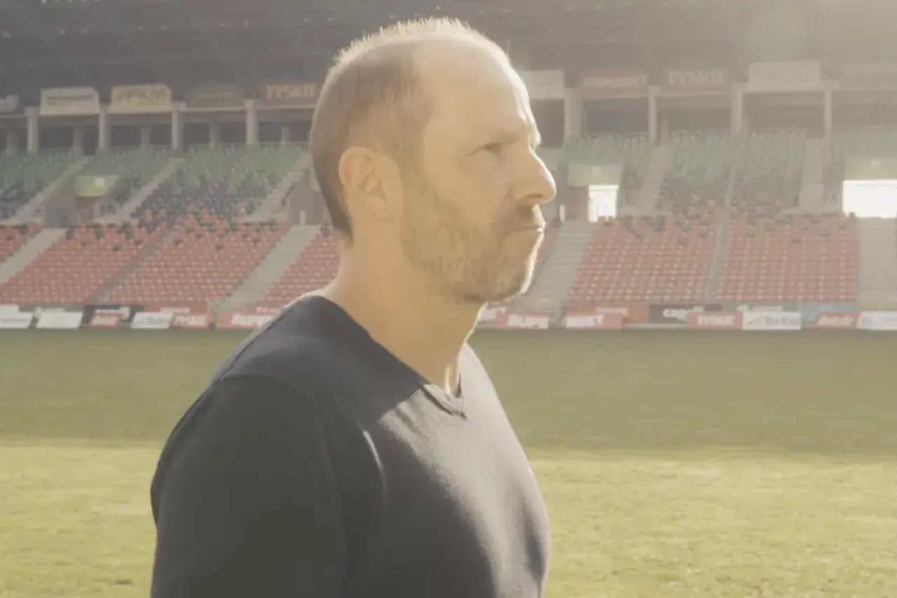GKS Tychy trener wpatruje się w pusty stadion, gotowy na kolejne wyzwania.