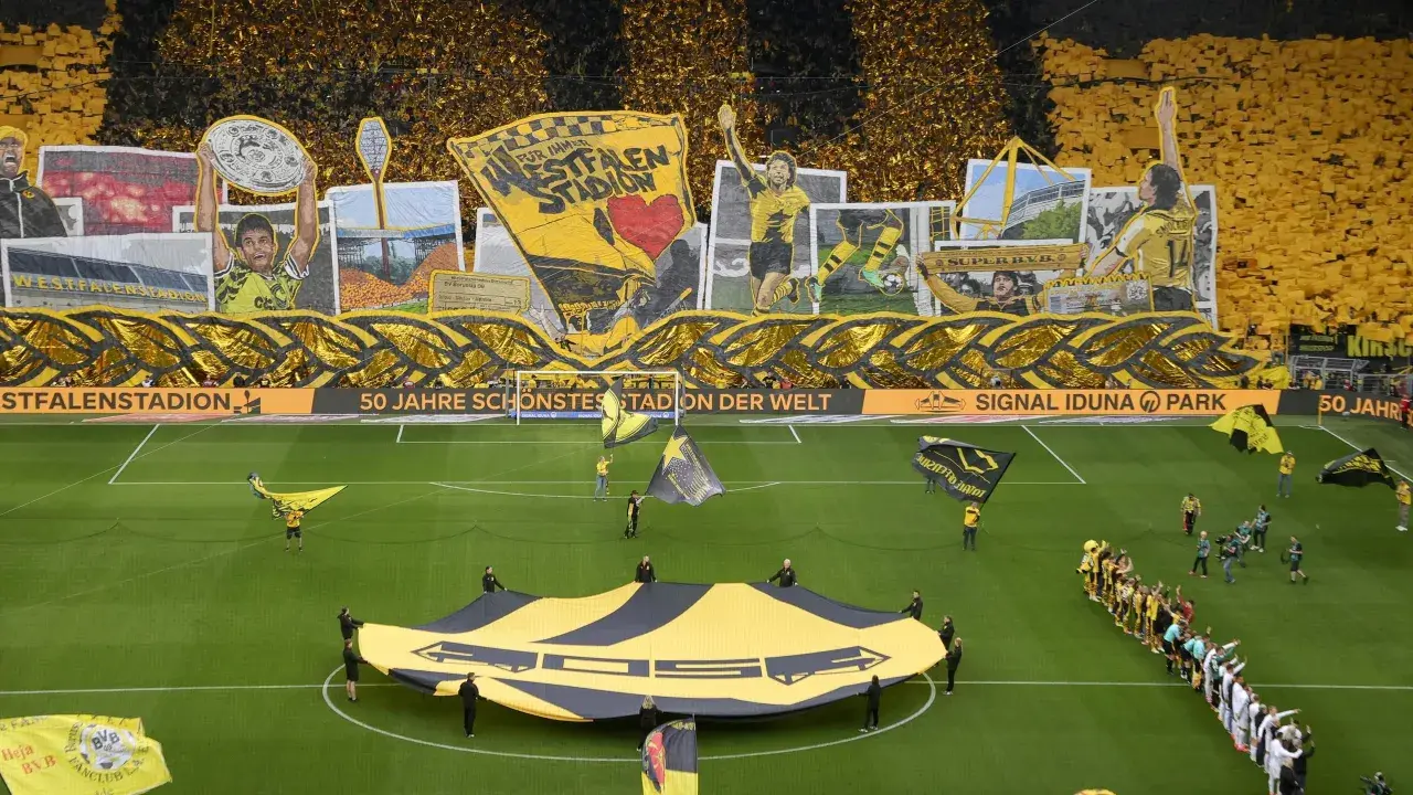 Wspaniała oprawa kibiców na stadionie Dortmund. Żółto-czarne barwy dominują, a fani tworzą gigantyczną flagę i transparenty.