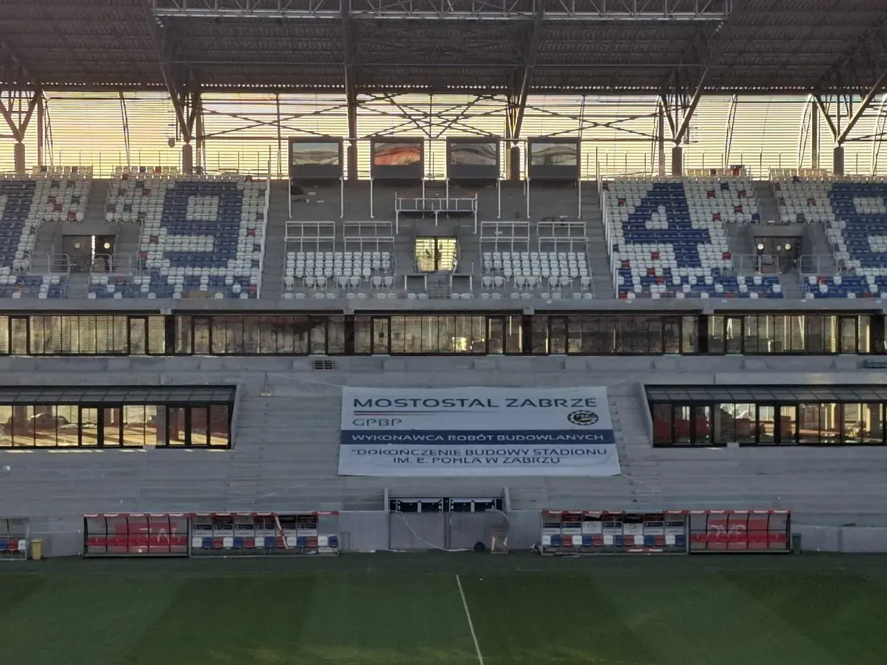 Pusta 4 trybuna stadionu Górnika Zabrze. Słońce odbija się w oknach.