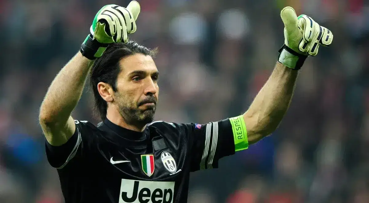 Buffon bramkarz w czarnej koszulce z zielonymi rękawicami, unosi ręce w geście triumfu.