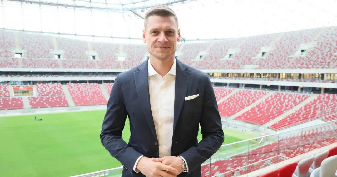 GKS Tychy trener w garniturze na tle stadionu.