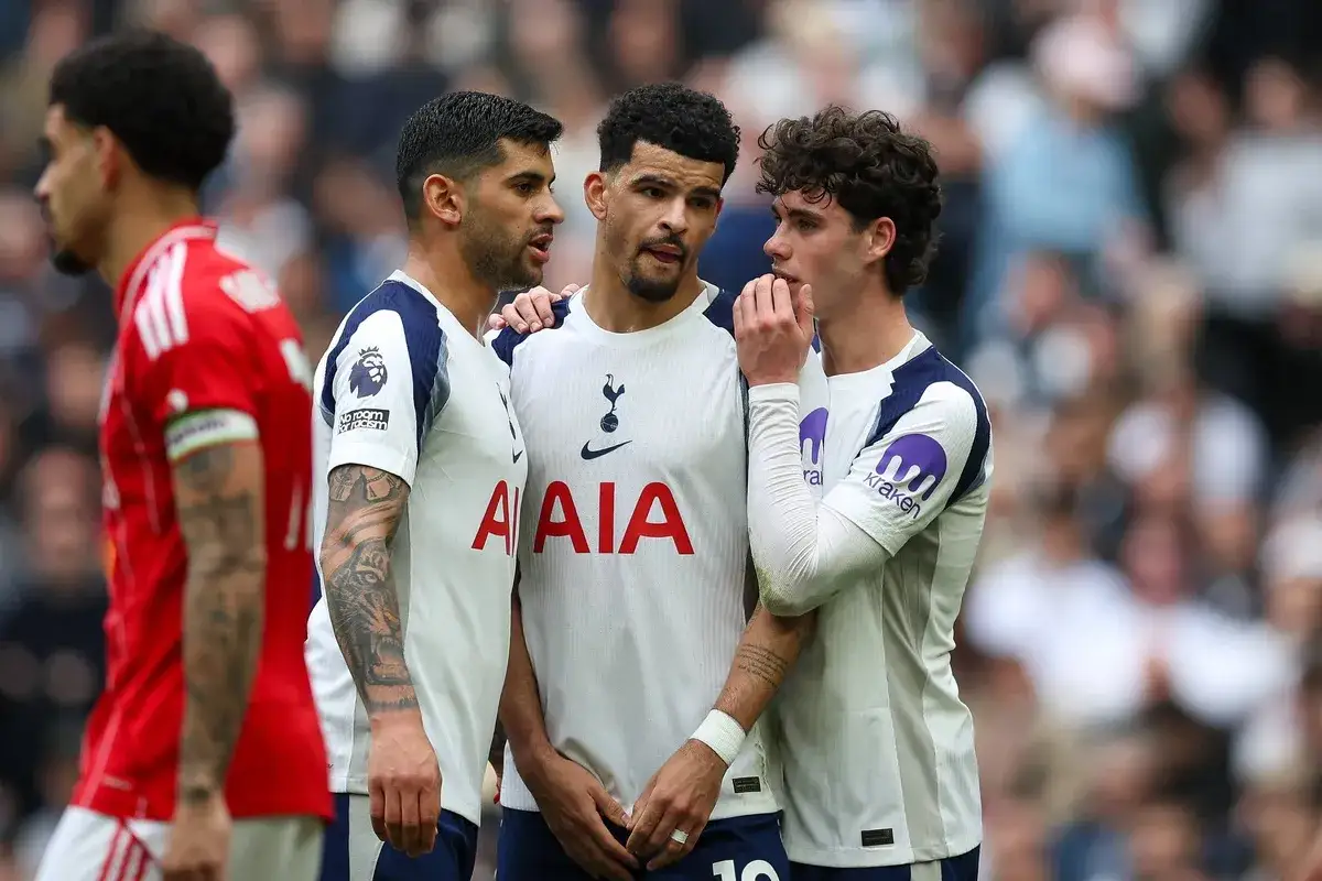 Trzech piłkarzy Tottenhamu w białych koszulkach rozmawia na boisku. To część składu Tottenhamu.