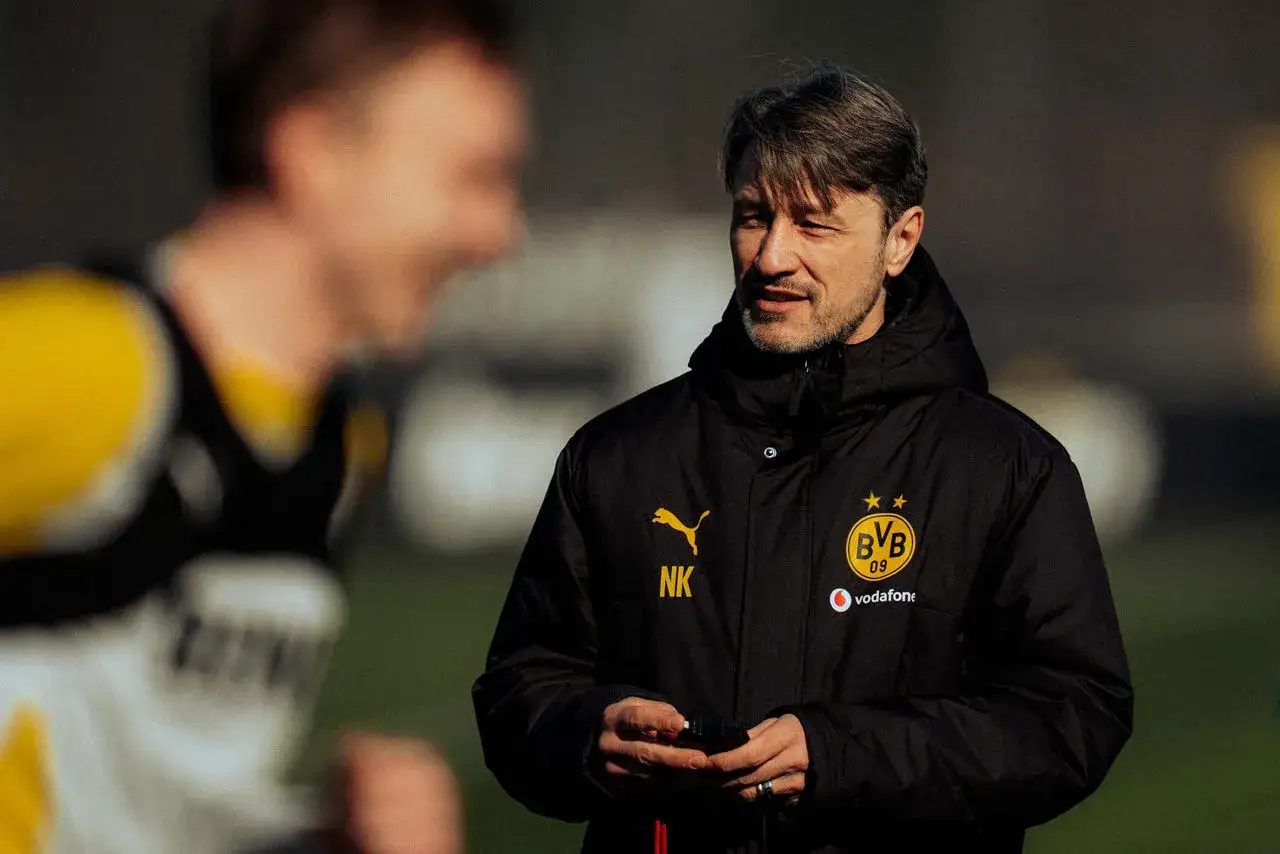 Trener Borussii Dortmund, w czarnej kurtce z logo klubu, prowadzi trening.