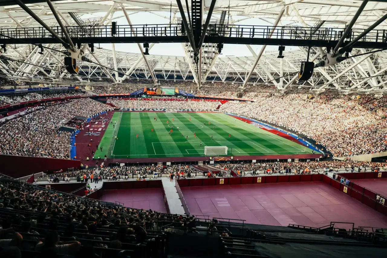 Widok na pełen widzów londyński stadion podczas meczu piłki nożnej.
