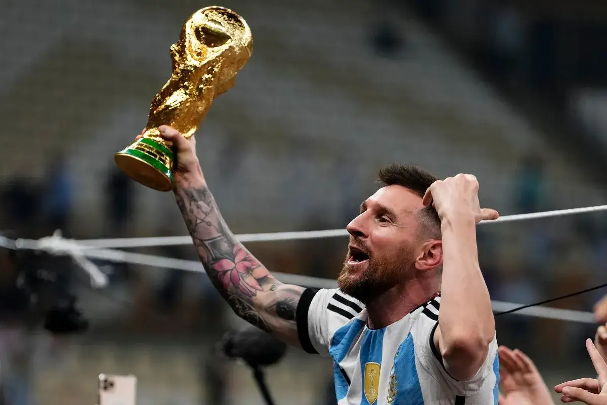 Lionel Messi z pucharem Mistrzostw Świata i Złotą Piłką