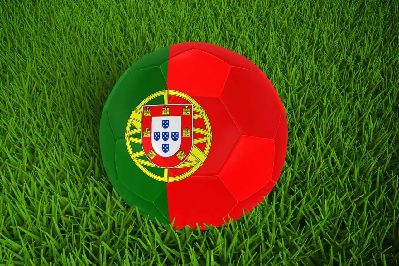 Piłka nożna z herbem Portugalii na zielonej trawie, gotowa do gry dla reprezentacji Portugalia FC.