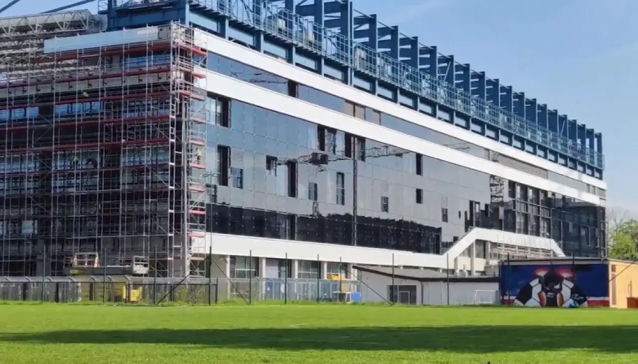 Stadion Wisły po remoncie widać w całej okazałości. Nowoczesna fasada ze szkła lśni w słońcu, a rusztowania świadczą o trwających pracach.